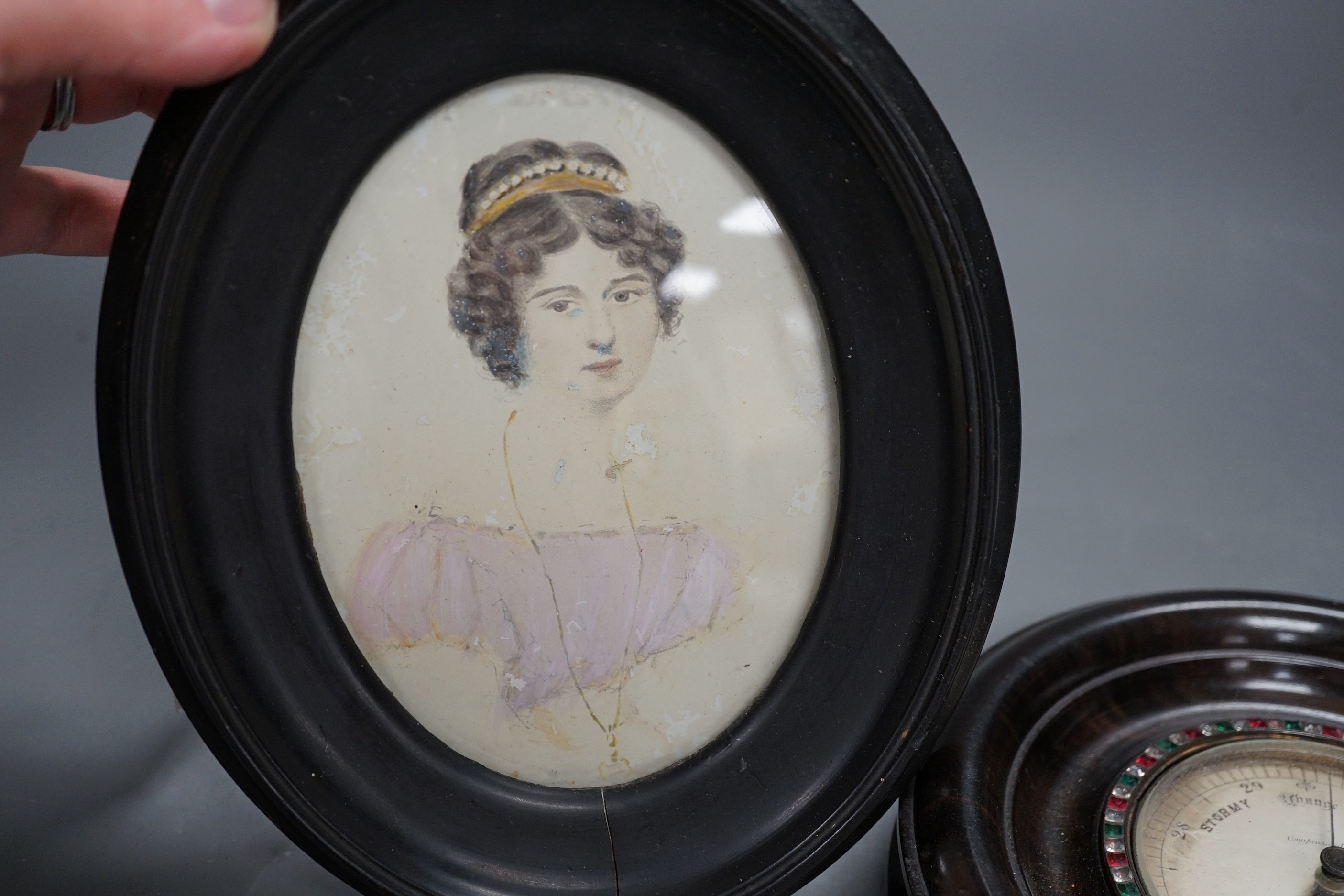 An early 19th century portrait miniature of a young lady, 12 x 9cm, together with a Blackie, 392, Strand, London small aneroid barometer with paste set bezel